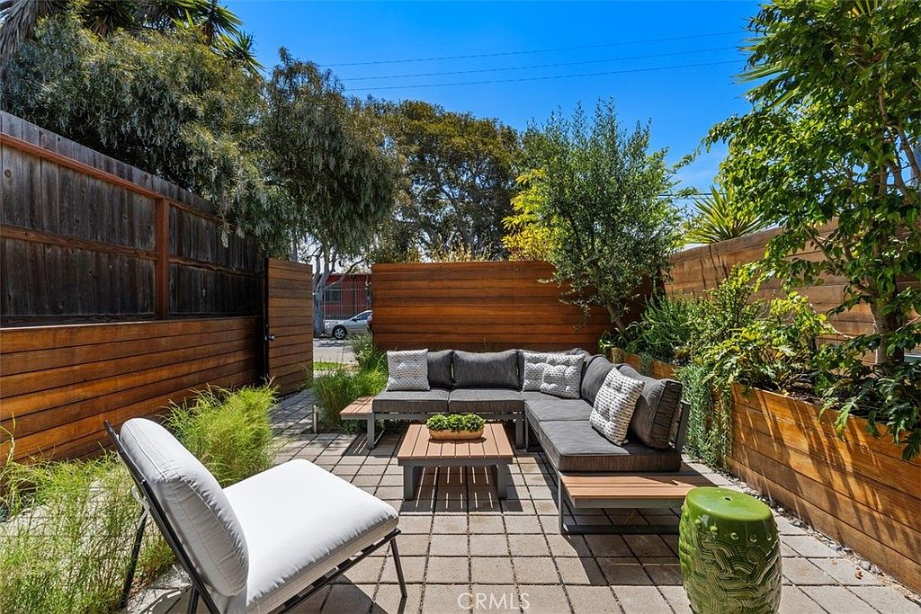 Private patio lounge with wood-fenced perimeter and modern outdoor sectional